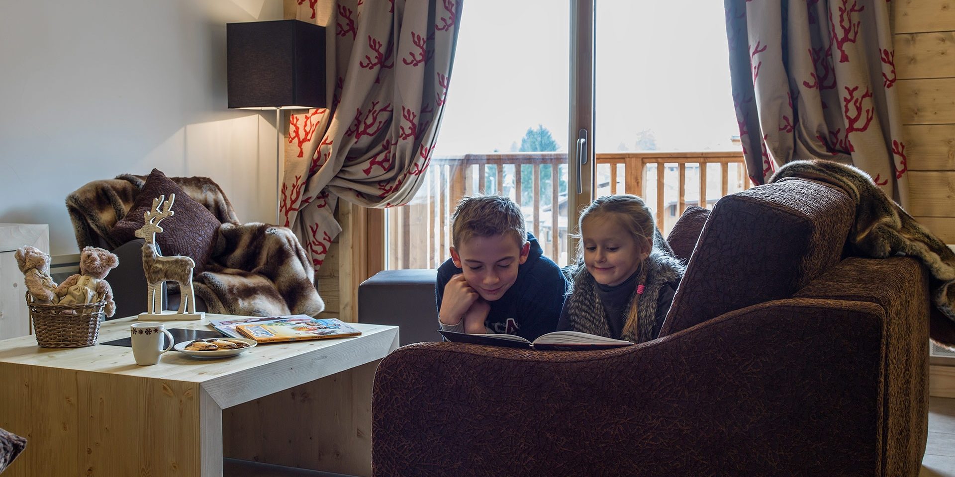 CGH Les Chalets de Layssia Samoens Le Grand Massif Frankrijk wintersport skivakantie luxe appartement woonkamer bank samen lezen ontspannen vakantie