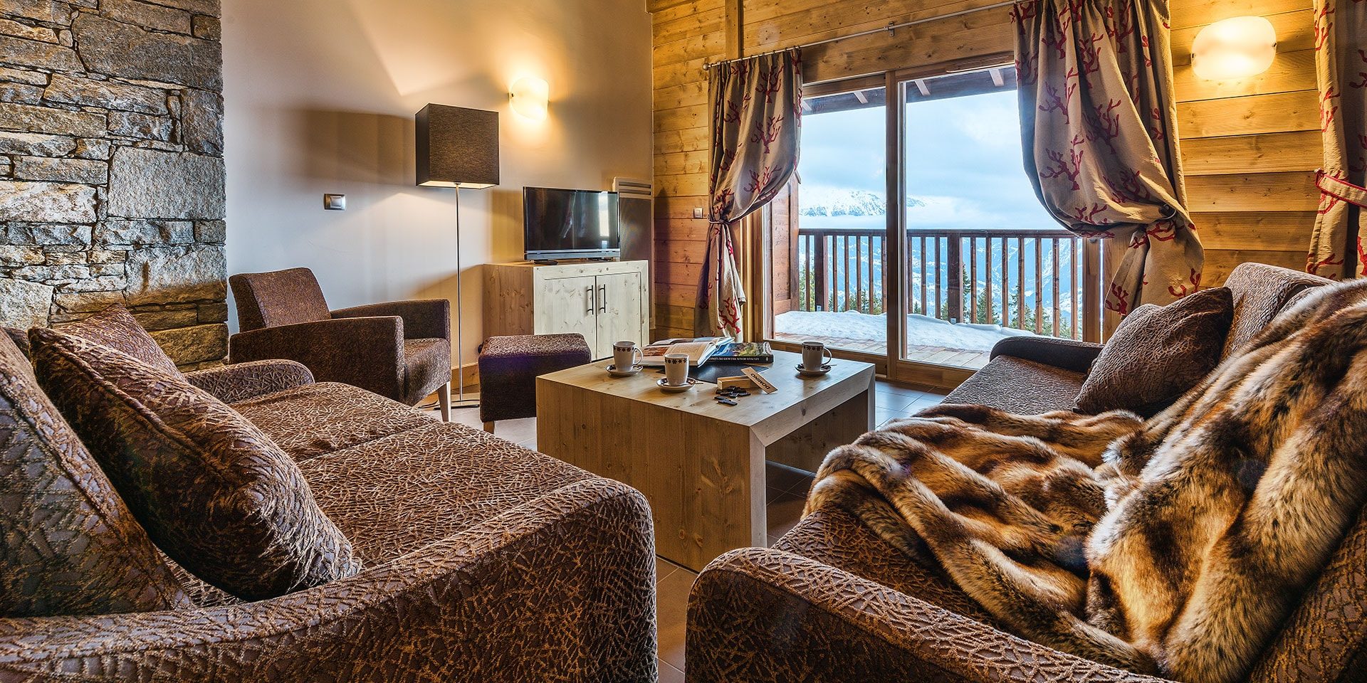 CGH Le Chalet Les Marmottons La Rosiere Espace San Bernardo Frankrijk wintersport skivakantie luxe woonkamer banken deken hout comfortabel modern authentiek
