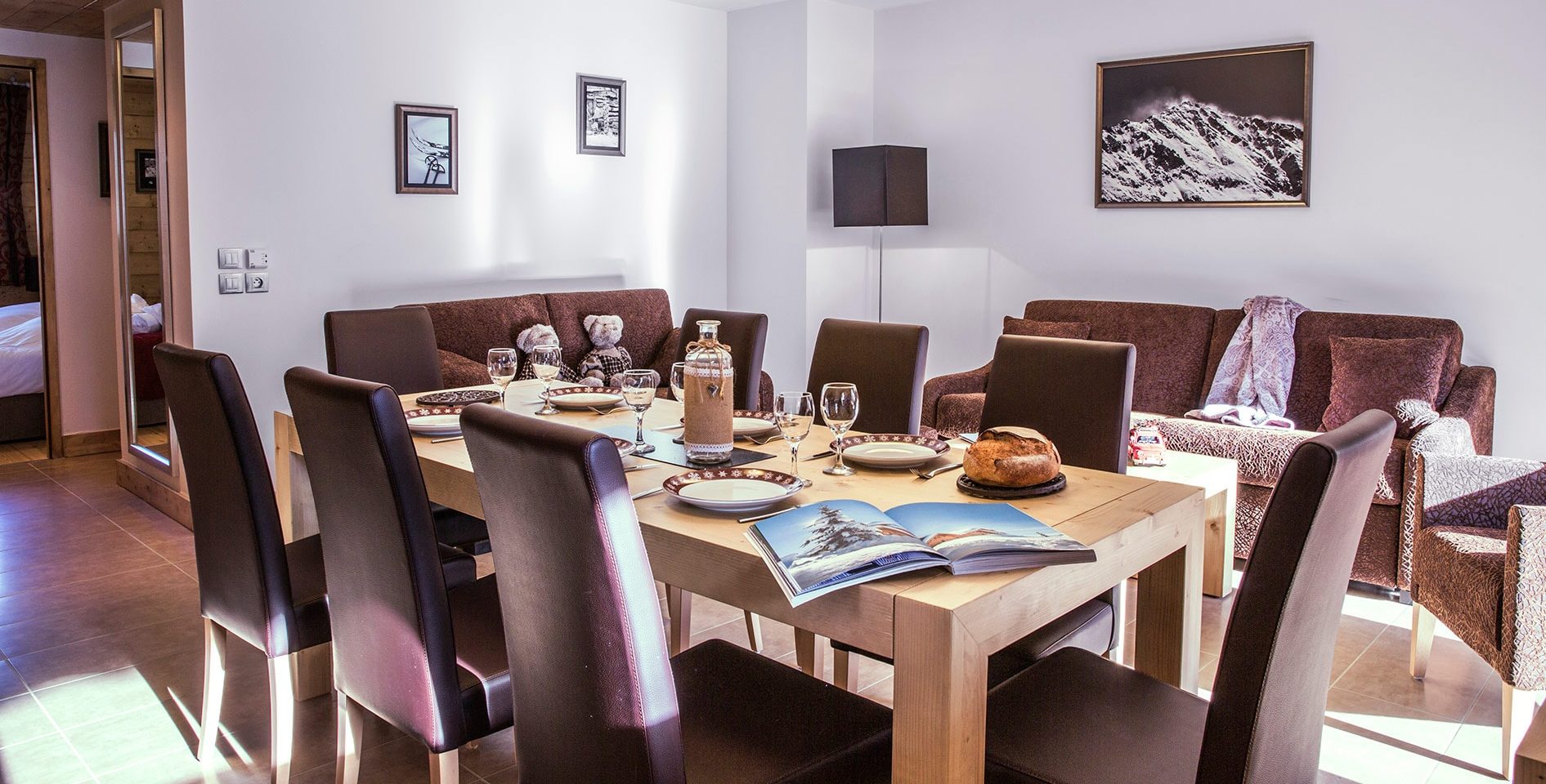 CGH La Grange aux Fees Valmorel Le Grand Domaine Frankrijk wintersport skivakantie luxe appartement woonkamer banken deken hout comfortabel modern eettafel grote gezin groepen gezellig eten