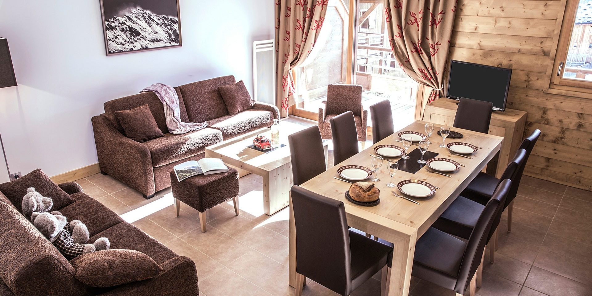 CGH La Grange aux Fees Valmorel Le Grand Domaine Frankrijk wintersport skivakantie luxe appartement woonkamer banken comfortabel knus modern eettafel grote groepen gezin eten gezellig
