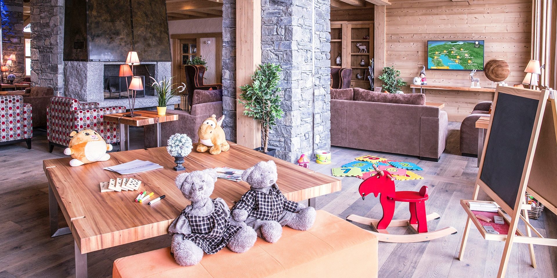 CGH La Grange aux Fees Valmorel Le Grand Domaine Frankrijk wintersport skivakantie luxe receptie welkom banken open haard speelgoed kinderen