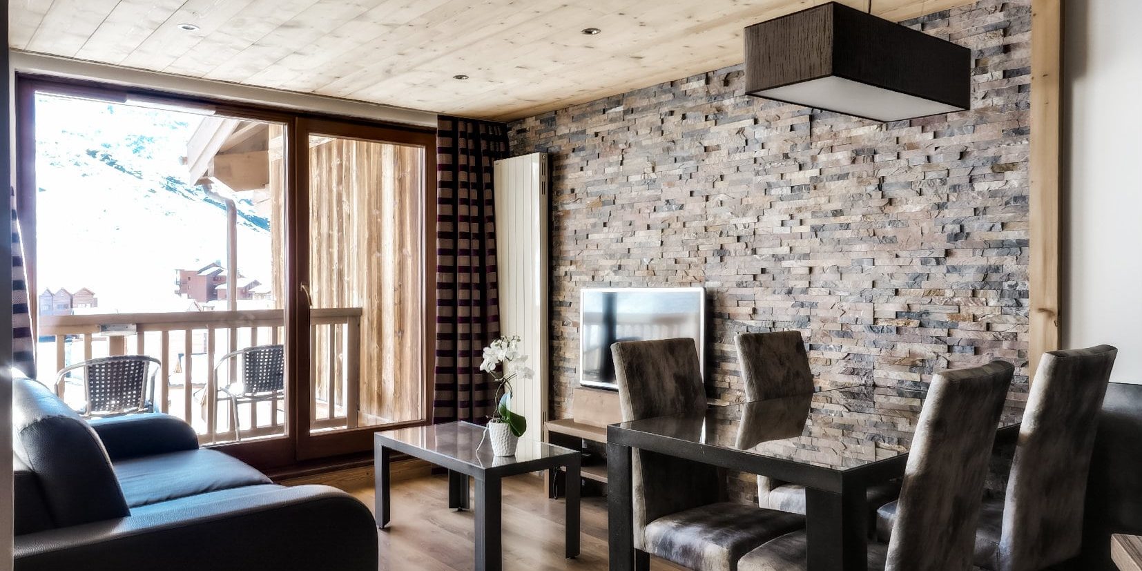 Koh I Nor Val Thorens Les 3 Vallees Frankrijk wintersport skivakantie luxe woonkamer chic modern design comfortabel stenen muur bank balkon uitzicht dorp