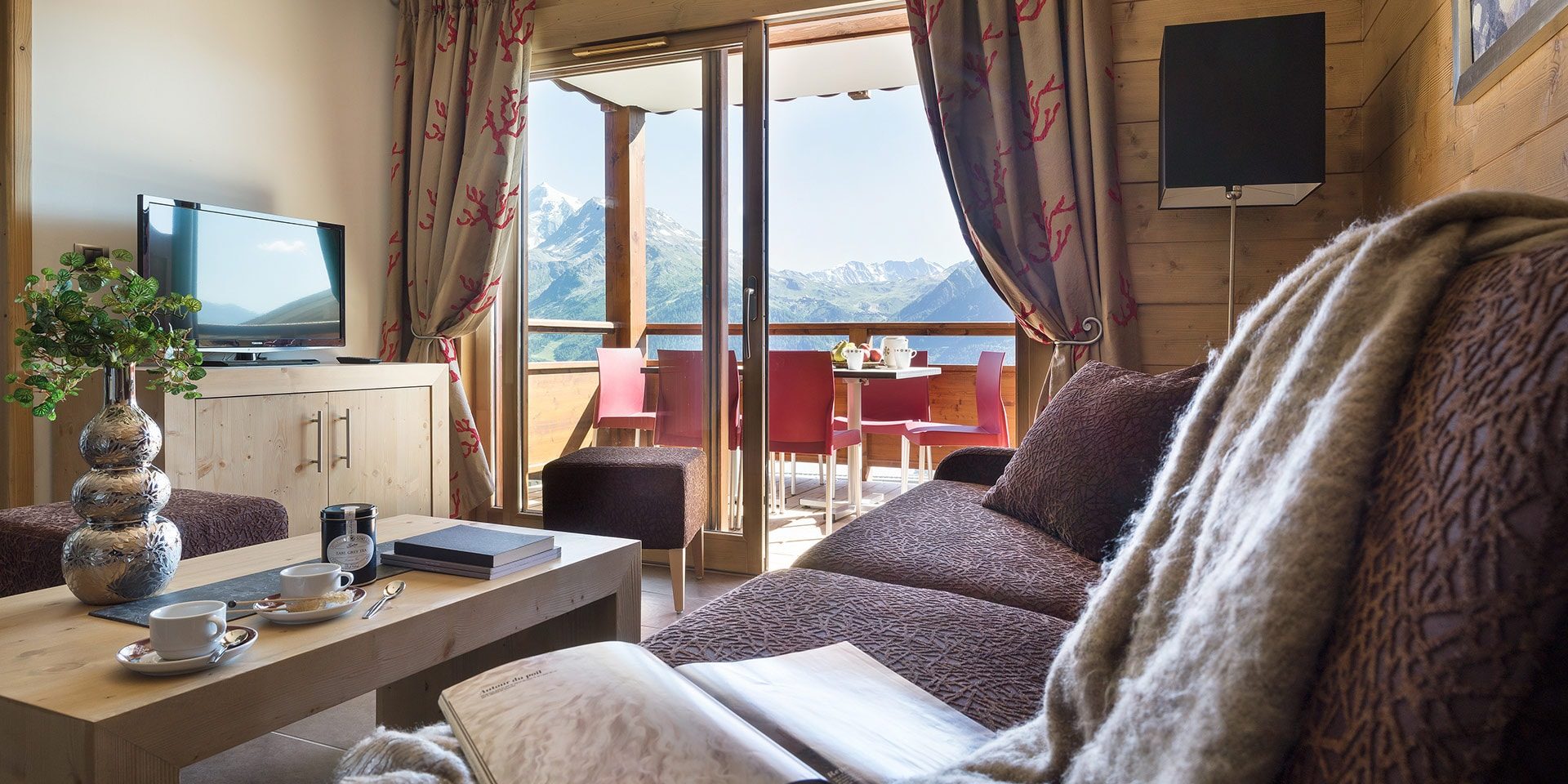 CGH Lodge Hemera La Rosiere Espace San Bernardo Frankrijk wintersport skivakantie luxe appartement bank modern woonkamer ontspannen terras tafel stoelen uitzicht bergen natuur