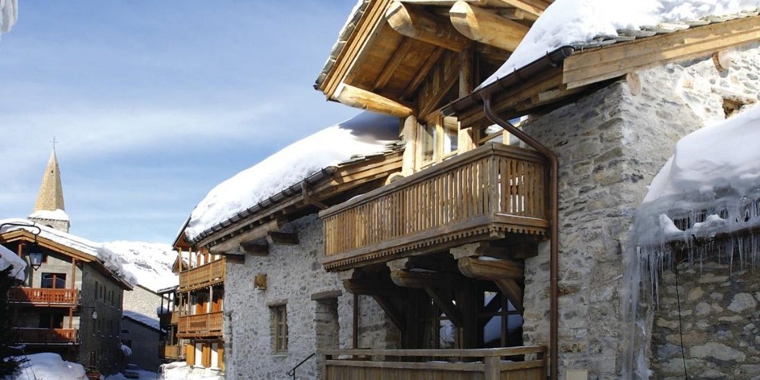 Chalet Farmhouse Val d'Isere Tignes-Val d'Isere Frankrijk wintersport skivakantie luxe voorkant chalet balkons ligging kerk