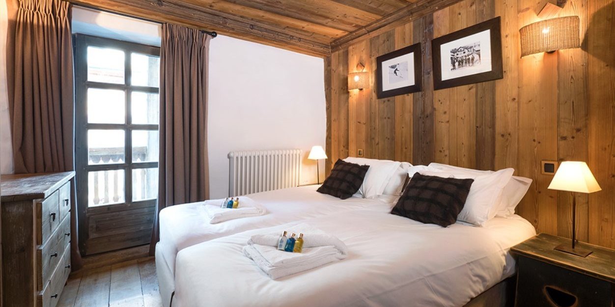 Chalet Farmhouse Val d'Isere Tignes-Val d'Isere Frankrijk wintersport skivakantie luxe slaapkamer bruine kussens kastje balkon