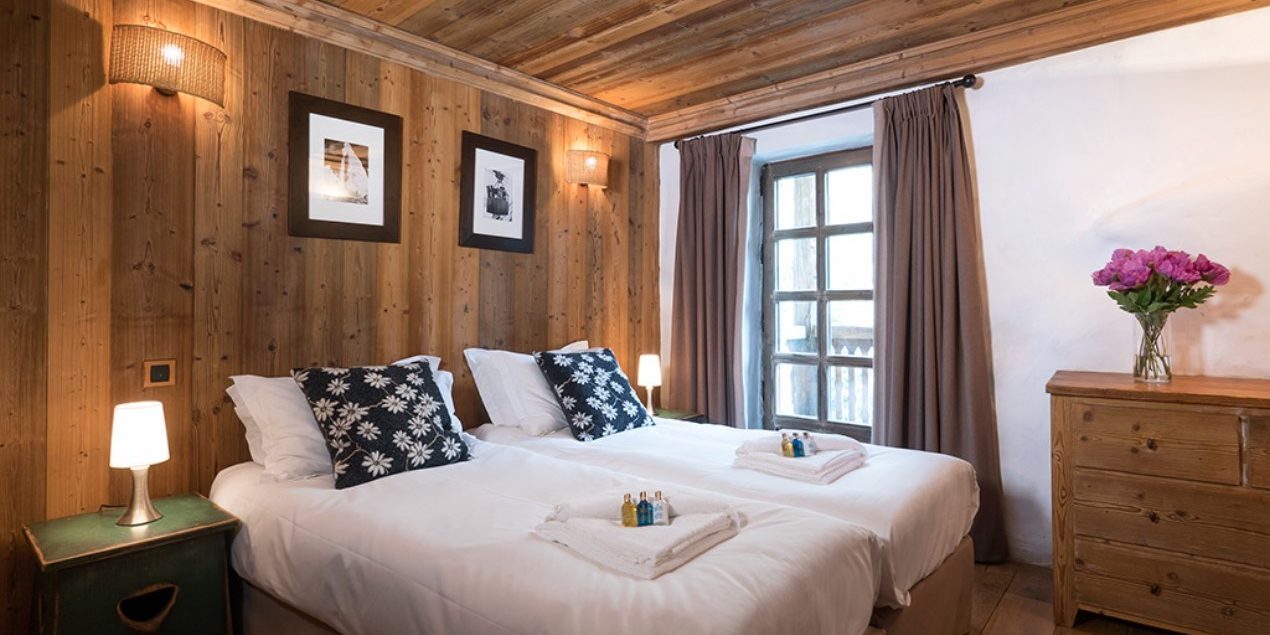 Chalet Farmhouse Val d'Isere Tignes-Val d'Isere Frankrijk wintersport skivakantie luxe slaapkamer aparte bedden bloemetjes kussens raam kastje bloemen
