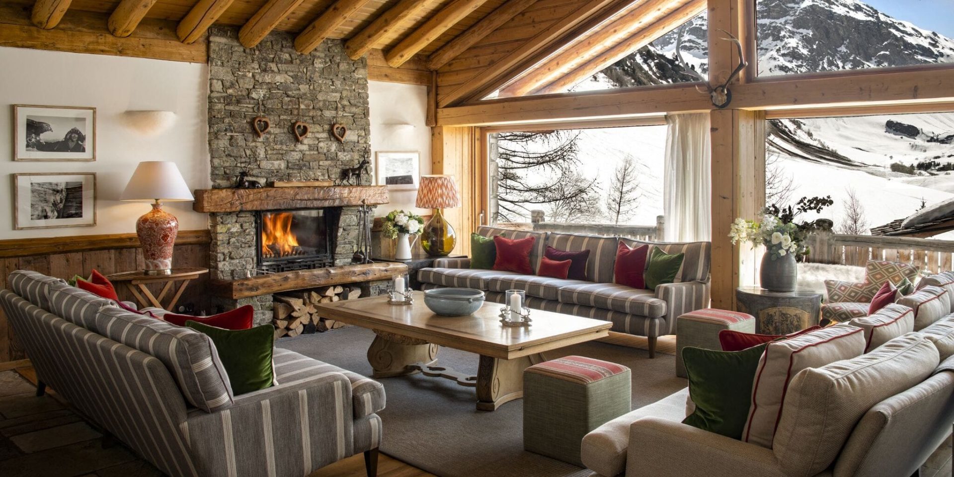 Chalet Mistral Val d'Isere Tignes-Val d'Isere Frankrijk wintersport skivakantie luxe living banken kussens open haard salontafel schilderijen uitzicht sneeuw bomen