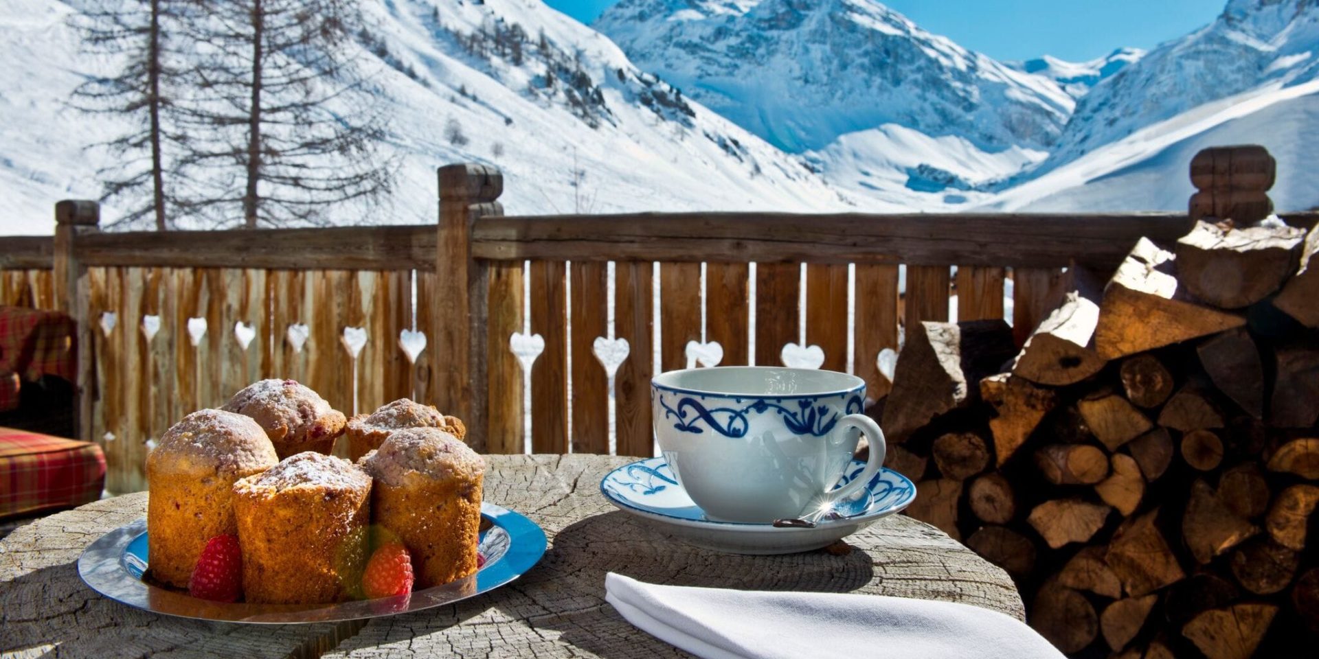 Chalet Mistral Val d'Isere Tignes-Val d'Isere Frankrijk wintersport skivakantie luxe ontbijt op balkon high tea cakes theekopje uitzicht sneeuw bomen hout