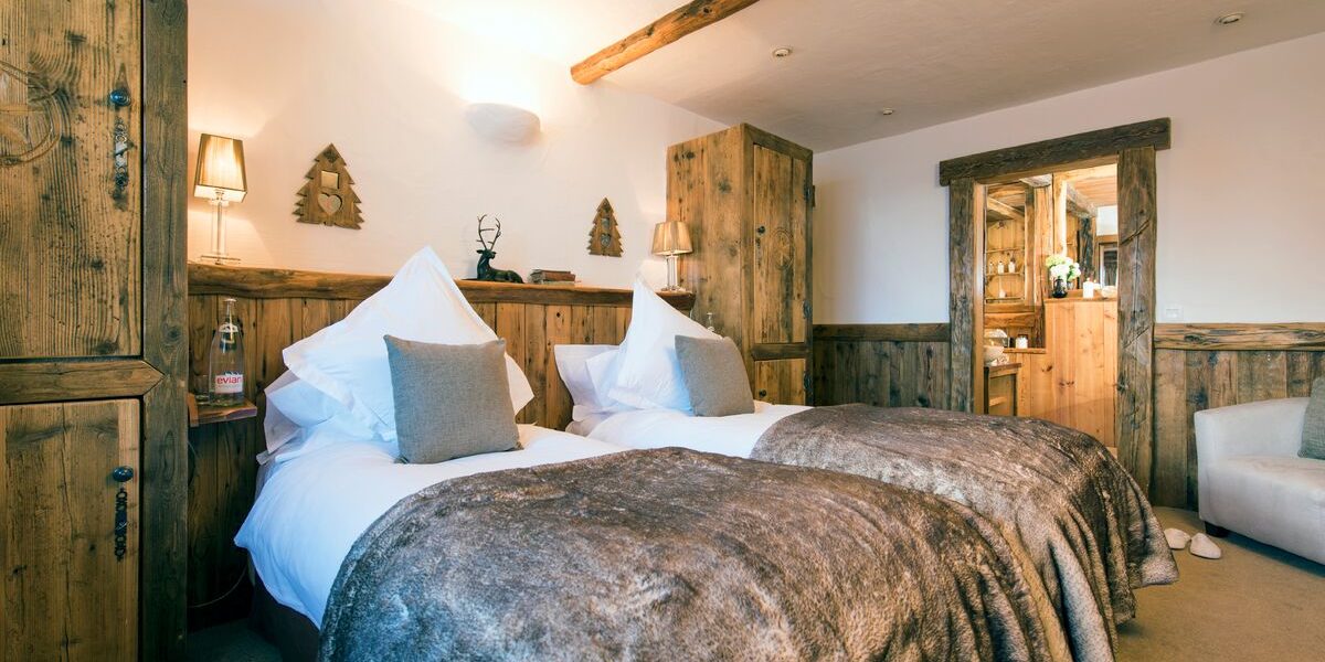 Chalet Mistral Val d'Isere Tignes-Val d'Isere Frankrijk wintersport skivakantie luxe slaapkamer Halo aparte bedden bruine kleden fauteuil badkamer hout