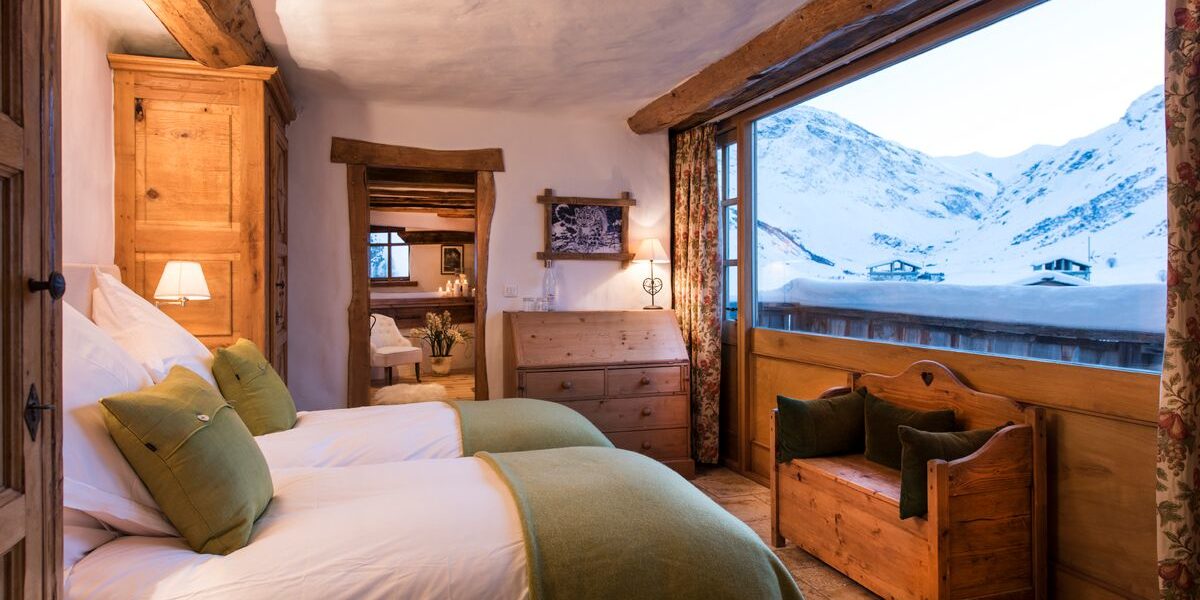 Chalet Mistral Val d'Isere Tignes-Val d'Isere Frankrijk wintersport skivakantie luxe slaapkamer Solstice aparte bedden bankje kussens fauteuil uitzicht sneeuw