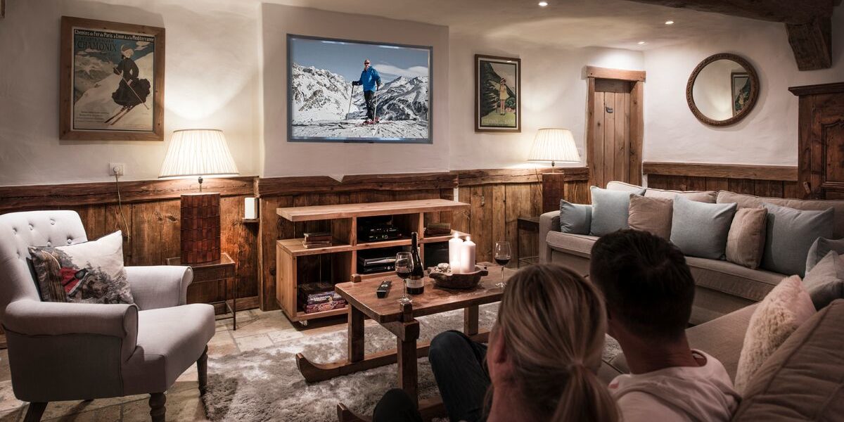 Chalet Mistral Val d'Isere Tignes-Val d'Isere Frankrijk wintersport skivakantie luxe TV kamer banken kussens fauteuil wijn kaarsen schilderijen