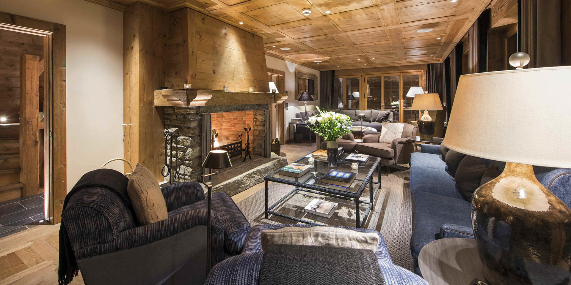 Chalet Chouqui Verbier Les 4 Vallees Zwitserland wintersport skivakantie luxe living open haard banken kussens fauteuils zithoek salontafel lampen