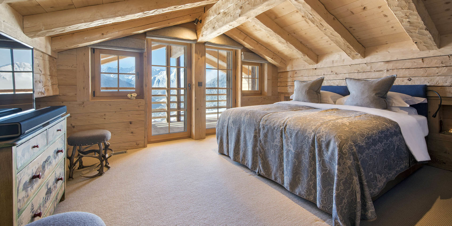 Chalet Chouqui Verbier Les 4 Vallees Zwitserland wintersport skivakantie luxe slaapkamer 2-persoonsbed kussens TV raam uitzicht sneeuw houten balken