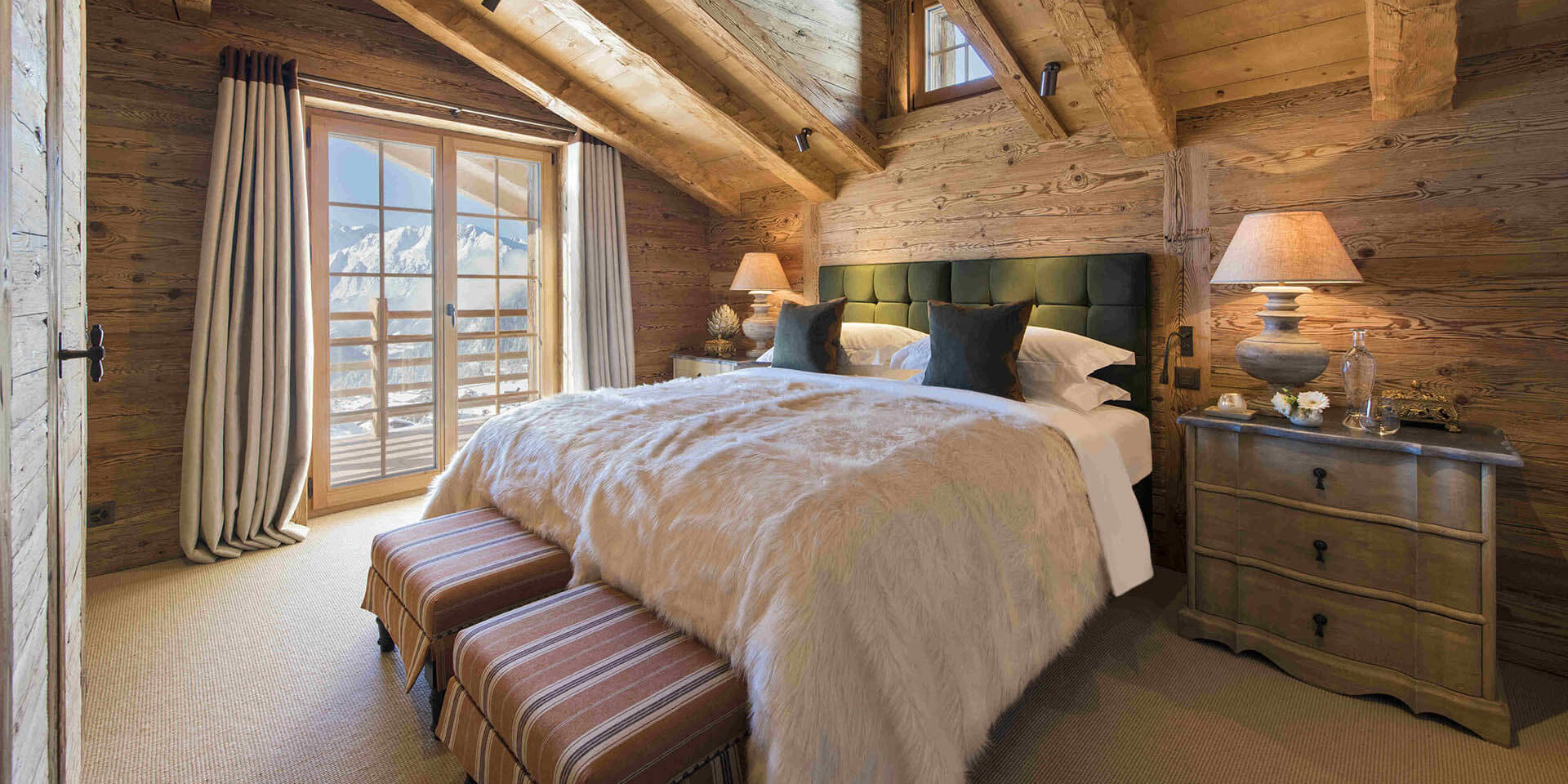 Chalet Chouqui Verbier Les 4 Vallees Zwitserland wintersport skivakantie luxe slaapkamer 2-persoonsbed hockers groene kussens raam kast houten balken