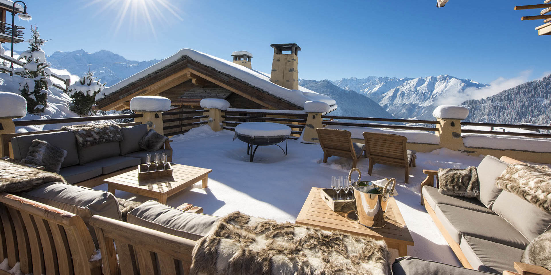 Chalet Chouqui Verbier Les 4 Vallees Zwitserland wintersport skivakantie luxe terras hoekbank salontafels Champagne glazen vuurkorf ligstoelen fantastisch uitzicht sneeuw bergen