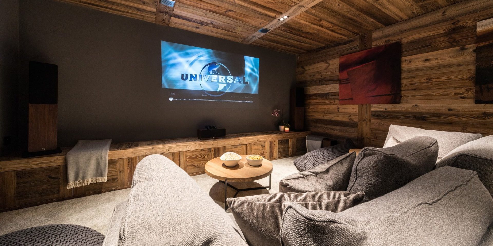 Chalet Joux Plane Morzine Les Portes du Soleil Frankrijk wintersport skivakantie luxe bioscoop lounge bank kussens hout groot projectiescherm salontafel
