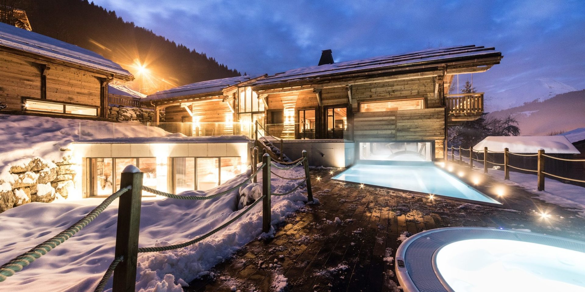 Chalet Joux Plane Morzine Les Portes du Soleil Frankrijk wintersport skivakantie luxe outdoor zwembad hot tub sneeuw bergen hout by night