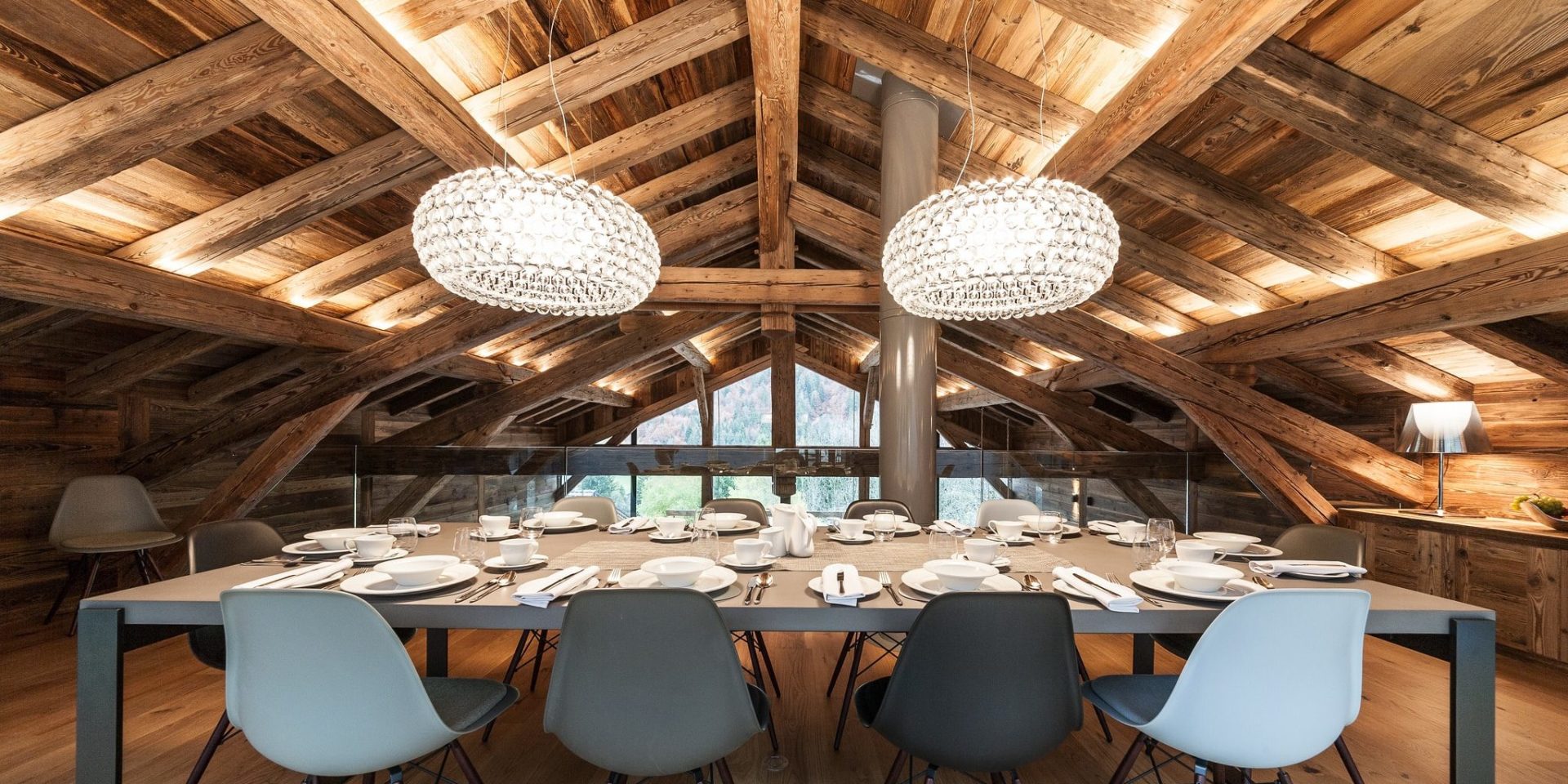 Chalet Joux Plane Morzine Les Portes du Soleil Frankrijk wintersport skivakantie luxe mezzanine eetkamer gedekte tafel grote lampen ramen houten balken
