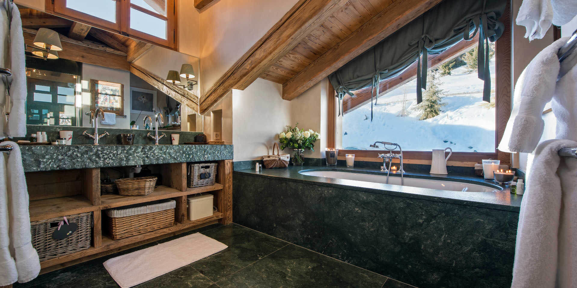 Chalet Nyumba Verbier Les 4 Vallees Zwitserland wintersport skivakantie luxe badkamer bad dubbele wasbak kastje handdoeken spiegel raam uitzicht sneeuw Bamford Organic Bath & Body-producten