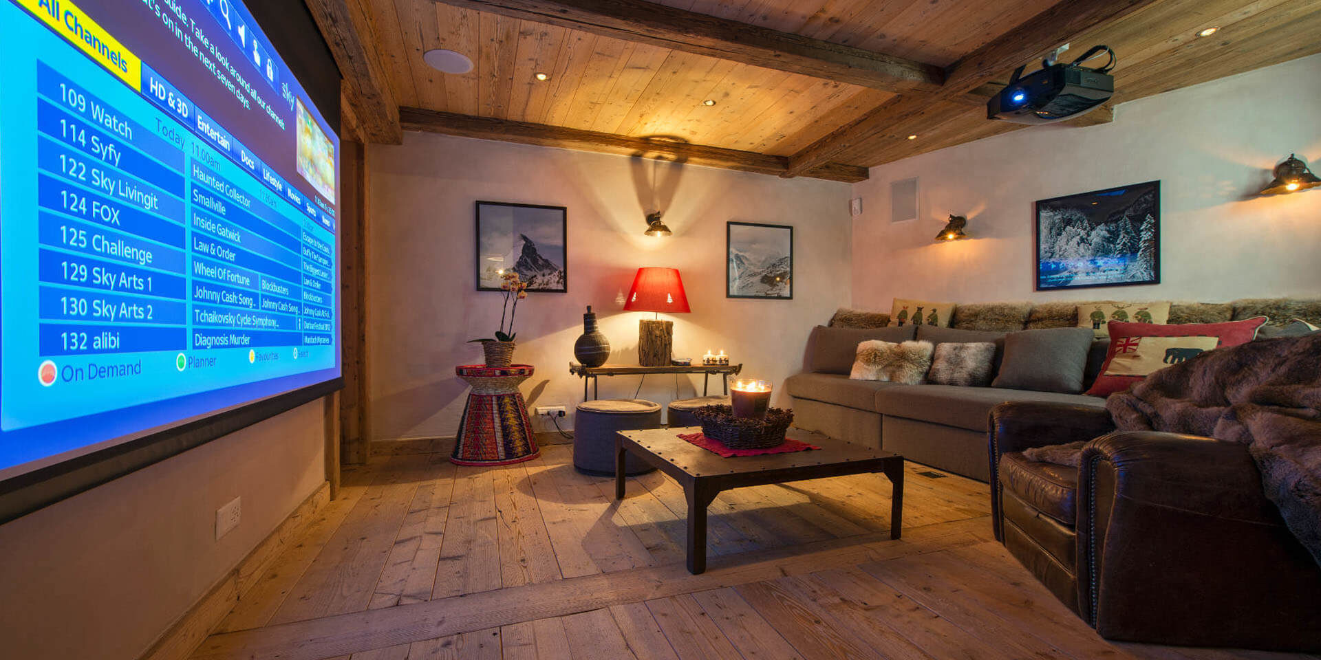 Chalet Nyumba Verbier Les 4 Vallees Zwitserland wintersport skivakantie luxe bioscoop banken fauteuil kussens salontafel decoratie groot projectiescherm