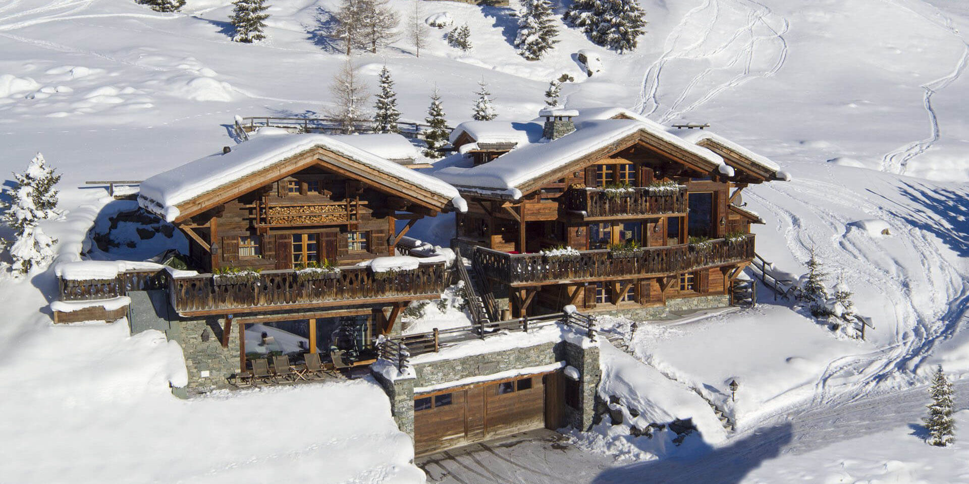 Chalet Nyumba Verbier Les 4 Vallees Zwitserland wintersport skivakantie luxe voorkant chalet garage terras ligstoelen sneeuw bomen