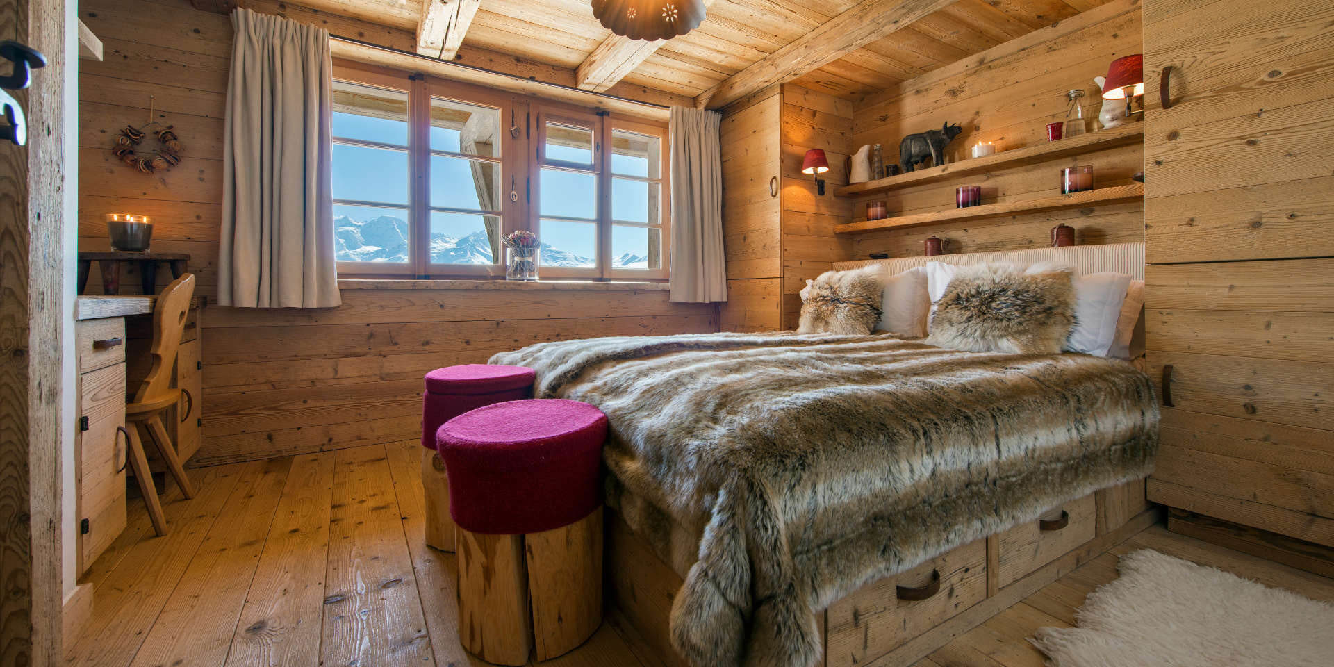 Chalet Nyumba Verbier Les 4 Vallees Zwitserland wintersport skivakantie luxe slaapkamer 2-persoonsbed hocker bureau stoel kaarsen decoratie raam