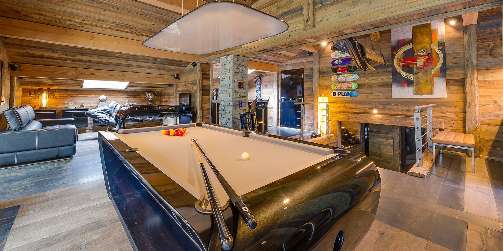 Chalet Quezac Tignes Tignes-Val d'Isere Frankrijk wintersport skivakantie luxe living pooltafel tafelvoetbal bank fauteuils relaxen hout