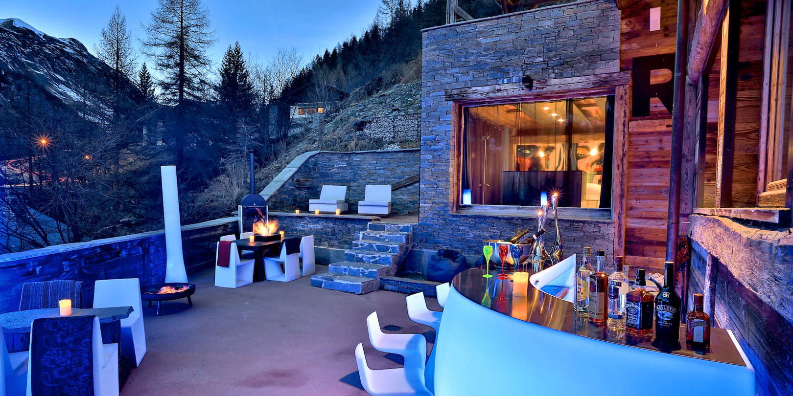 Chalet Quezac Tignes Tignes-Val d'Isere Frankrijk wintersport skivakantie luxe terras bar dranken vuurplaats zitjes stoelen tafels ligstoelen bomen bergen