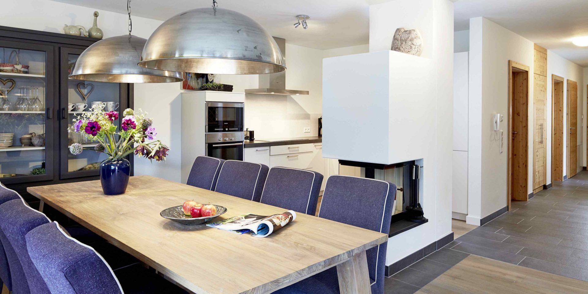 Kaprun Glacier Estate Zell am See-Kaprun Oostenrijk wintersport skivakantie luxe appartement K6 eettafel stoelen bloemen lampen keuken open haard kast