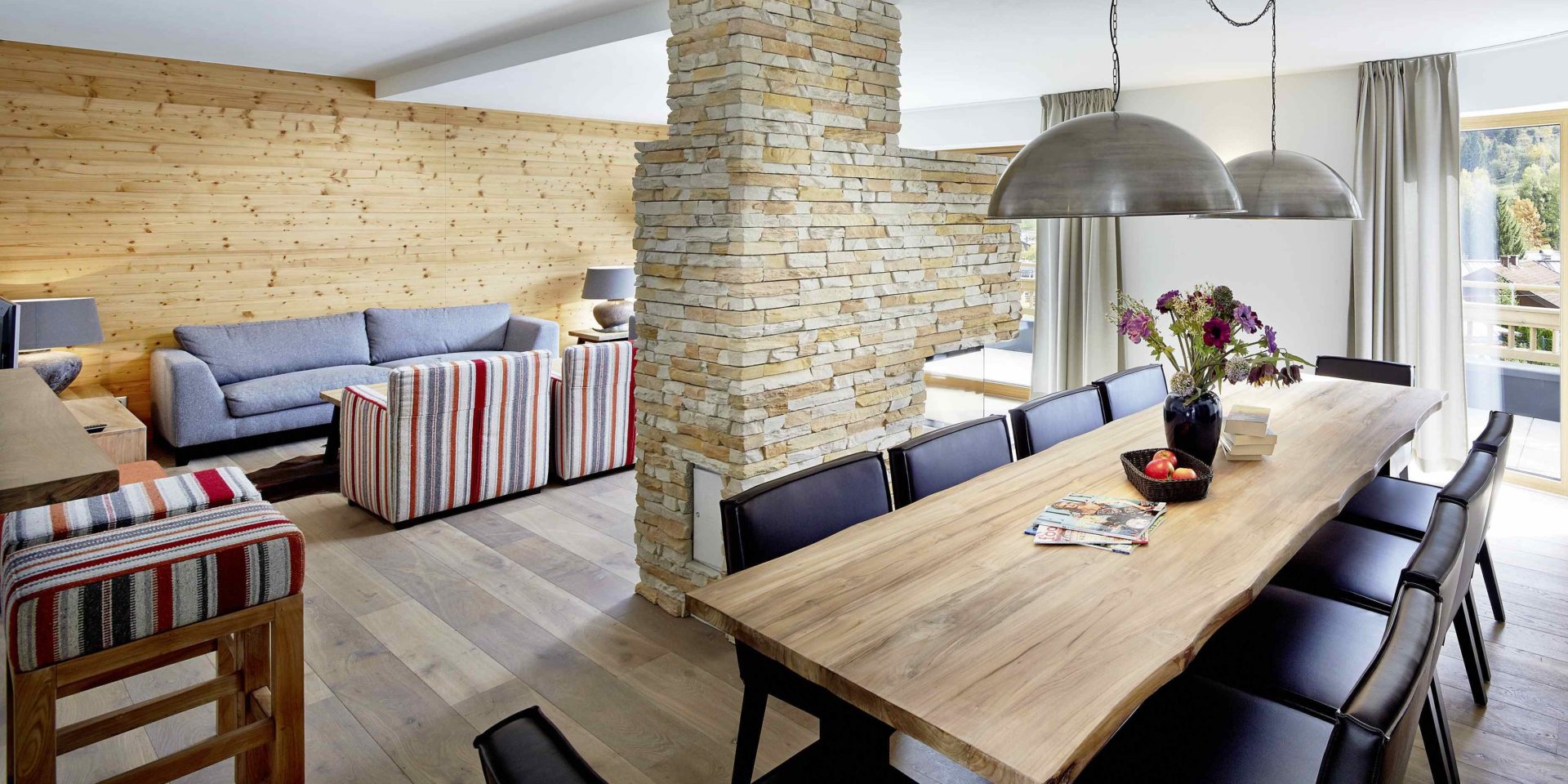 Kaprun Glacier Estate Zell am See-Kaprun Oostenrijk wintersport skivakantie luxe appartement K12 eettafel stoelen bloemen lampen kruk bank fauteuils stenen hout