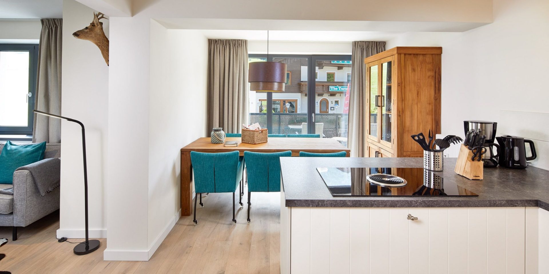 Kristall Plaza Niederau Wildschonau Oostenrijk wintersport skivakantie luxe appartement P6B eettafel blauwe stoelen lampen kast keuken raam bank lamp hert