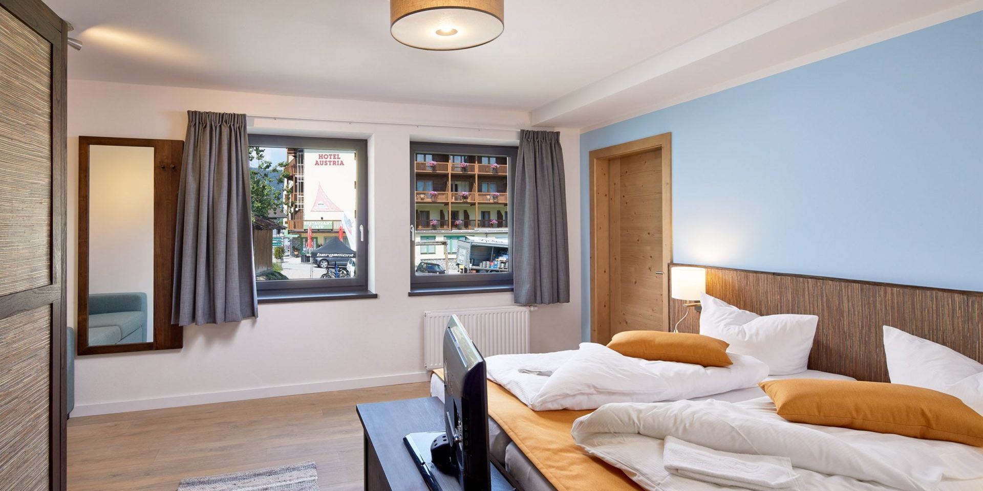 Kristall Plaza Niederau Wildschonau Oostenrijk wintersport skivakantie luxe appartement P6A slaapkamer aparte bedden bedsprei TV ramen spiegel blauwe muur lamp