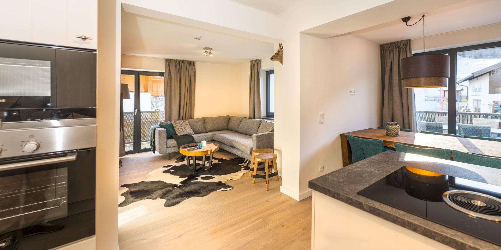 Kristall Plaza Niederau Wildschonau Oostenrijk wintersport skivakantie luxe appartement P6B hoekbank hoge ramen eettafel blauwe stoelen keuken balkon tafel stoelen