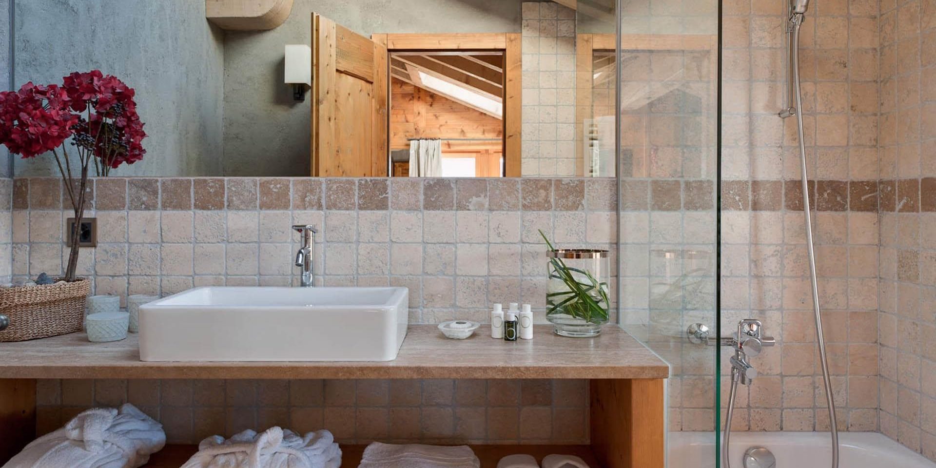 Chalet Pierre Avoi Verbier Les 4 Vallees Zwitserland wintersport skivakantie luxe badkamer douche wastafel bloemen badjassen handdoeken