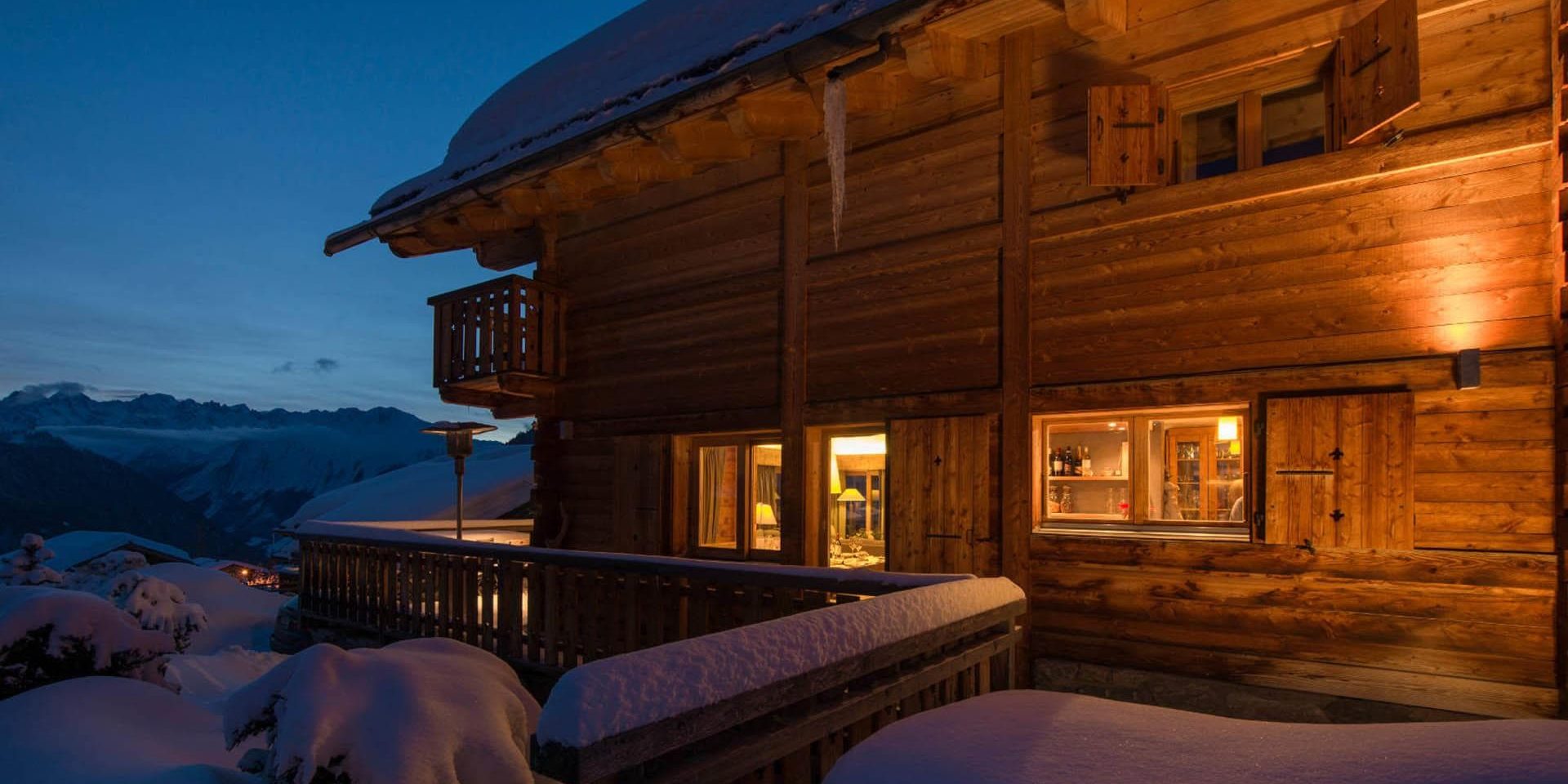 Chalet Pierre Avoi Verbier Les 4 Vallees Zwitserland wintersport skivakantie luxe chalet zijkant balkon ligging sneeuw uitzicht bergen by night