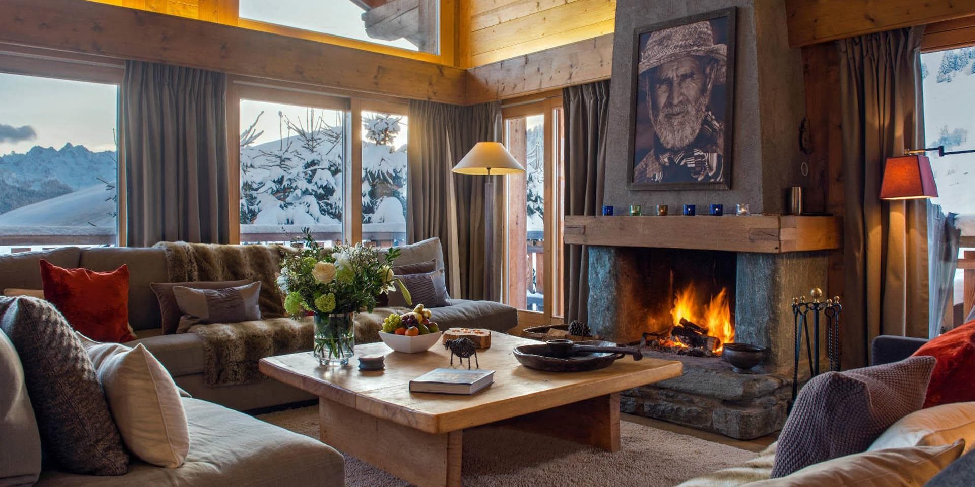 Chalet Pierre Avoi Verbier Les 4 Vallees Zwitserland wintersport skivakantie luxe living open haard schilderij banken kussens bloemen fruit sneeuw bergen uitzicht