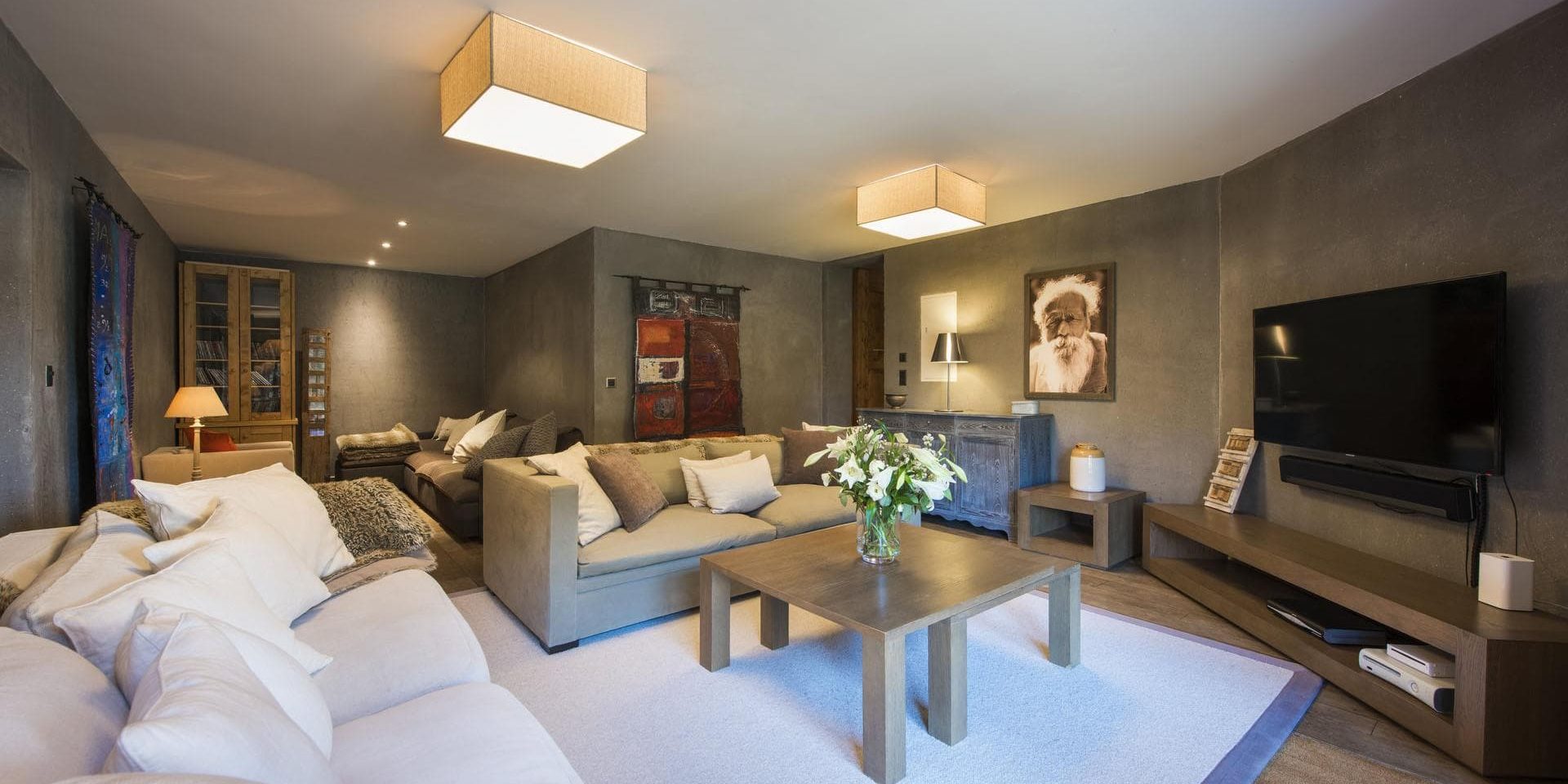 Chalet Pierre Avoi Verbier Les 4 Vallees Zwitserland wintersport skivakantie luxe TV kamer banken kussens salontafel bloemen kast vloerkleed schilderij