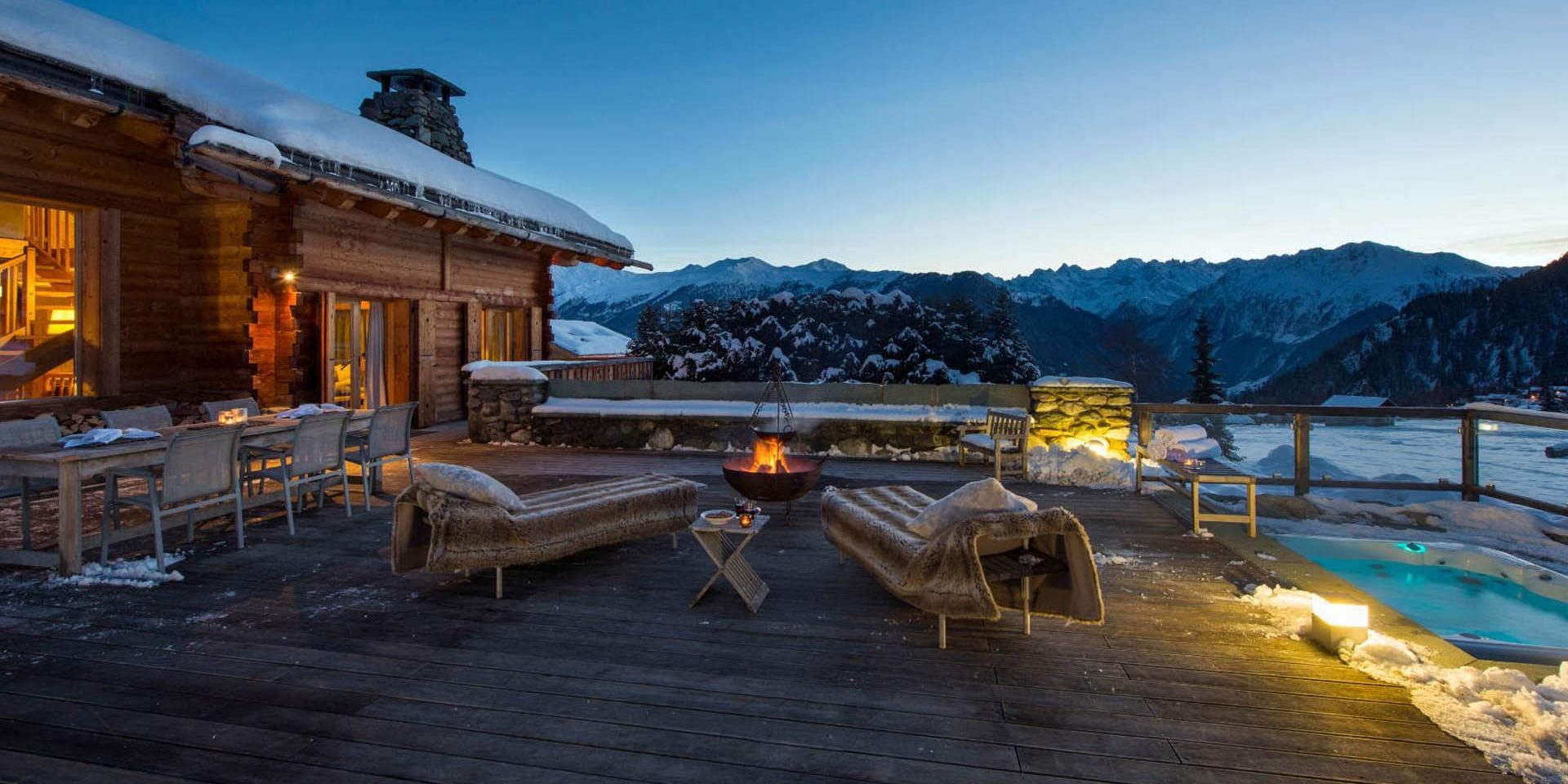 Chalet Pierre Avoi Verbier Les 4 Vallees Zwitserland wintersport skivakantie luxe groot terras hot tub ligstoelen eettafel stoelen vuurkorf sneeuw besneeuwde bomen uitzicht bergen