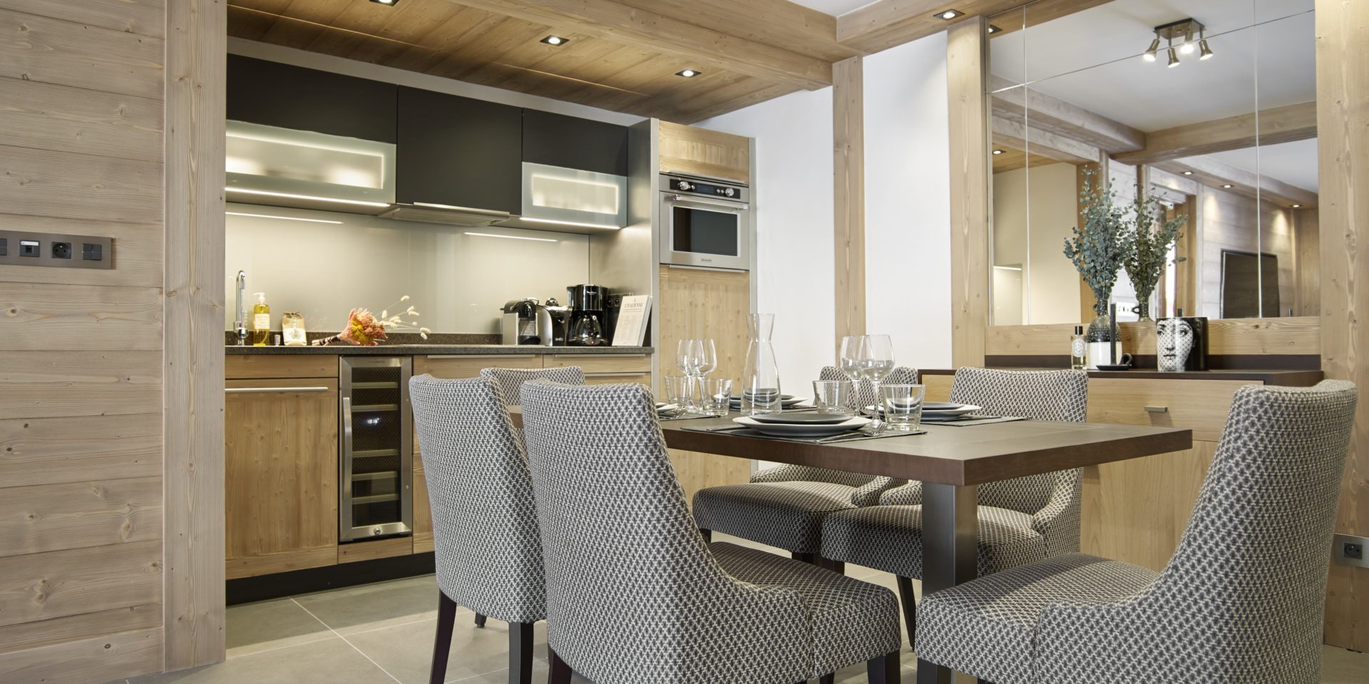 MGM Residence Anitea Valmorel Le Grand Domaine Frankrijk wintersport skivakantie luxe appartement eetkamer gedekte tafel steolen keuken spiegel plant