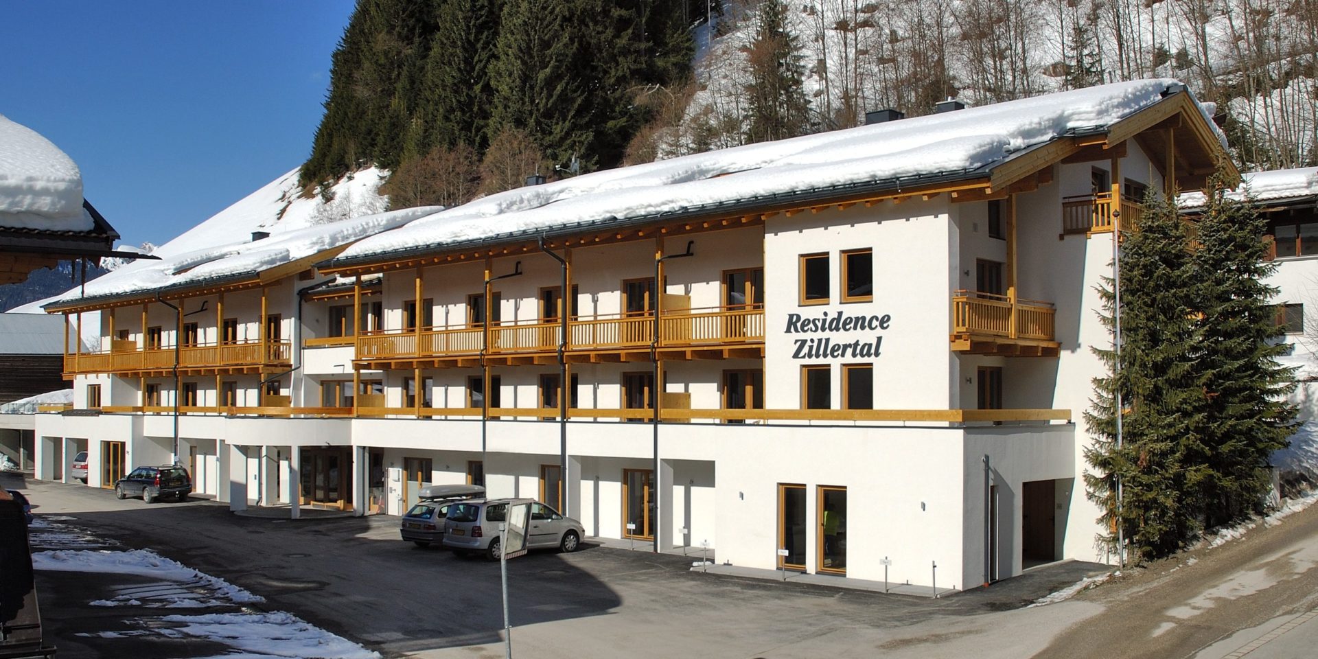 Residence Zillertal Gerlos Zillertal Arena Oostenrijk wintersport skivakantie luxe voorkant residence parking sneeuw bomen bergen