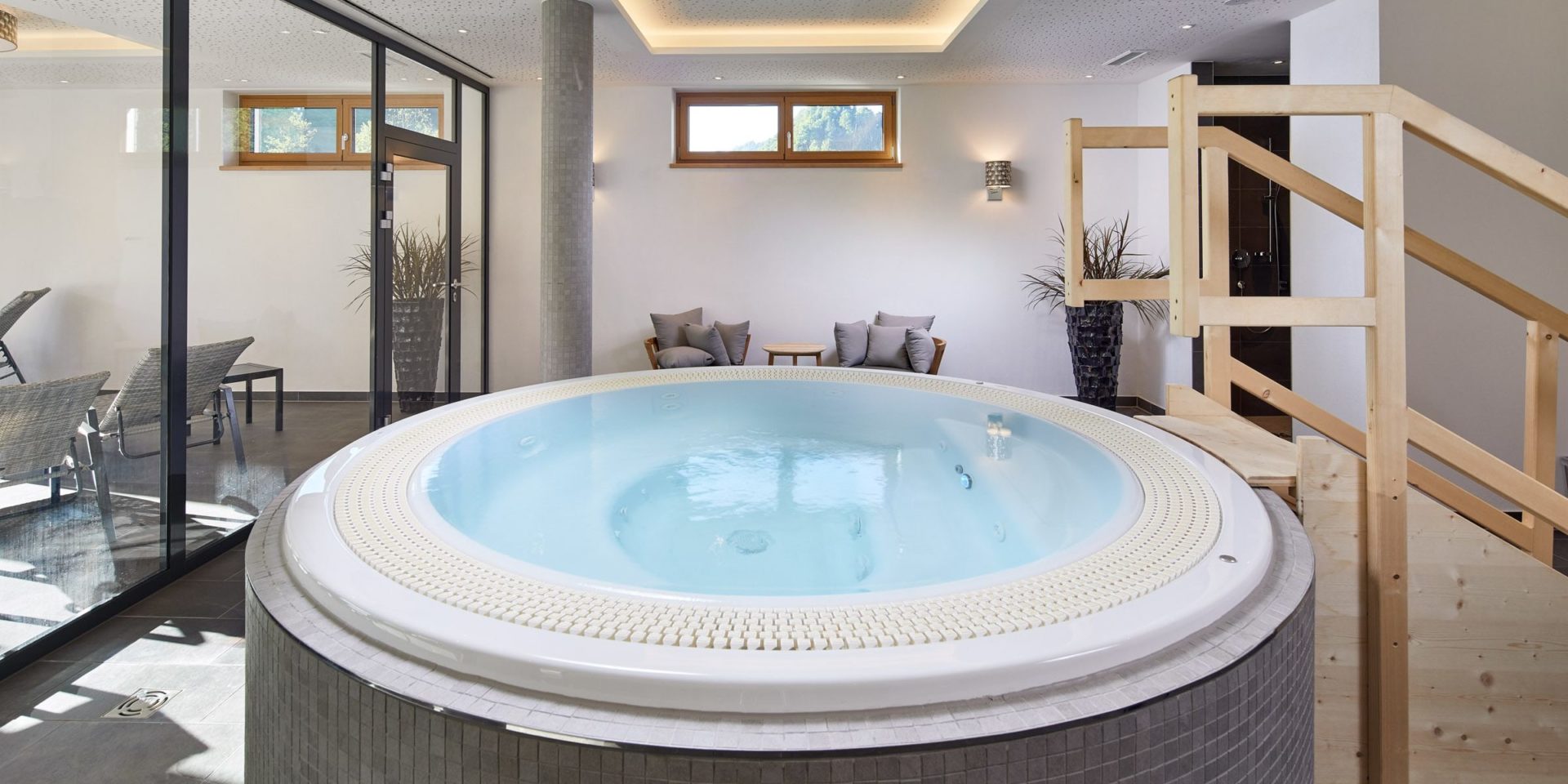 Residenz Drachenstein Niederau Wildschonau Oostenrijk wintersport skivakantie luxe jacuzzi zitje stoelen tafeltje ligstoelen plant raam ontspanning relaxen