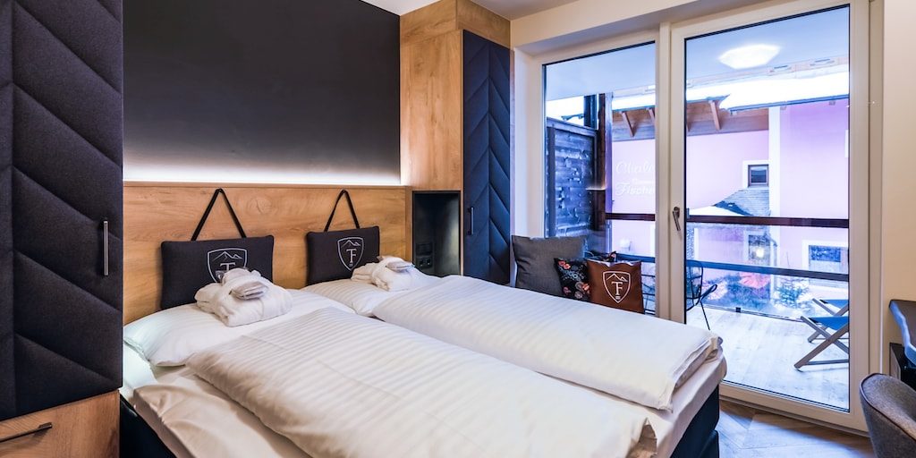 Hotel 24 by Avenida Kaprun Zell am See-Kaprun Oostenrijk wintersport skivakantie luxe 2-persoonskamer Cosy slaapkamer 2-persoonsbed bureau stoel kastenwand balkon ligstoelen