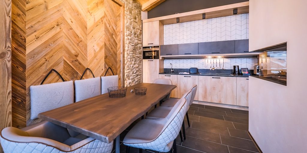 Hotel 24 by Avenida Kaprun Zell am See-Kaprun Oostenrijk wintersport skivakantie luxe Penthouse 3 slaapkamers eetkamer eettafel stoelen houten wand keuken open haard