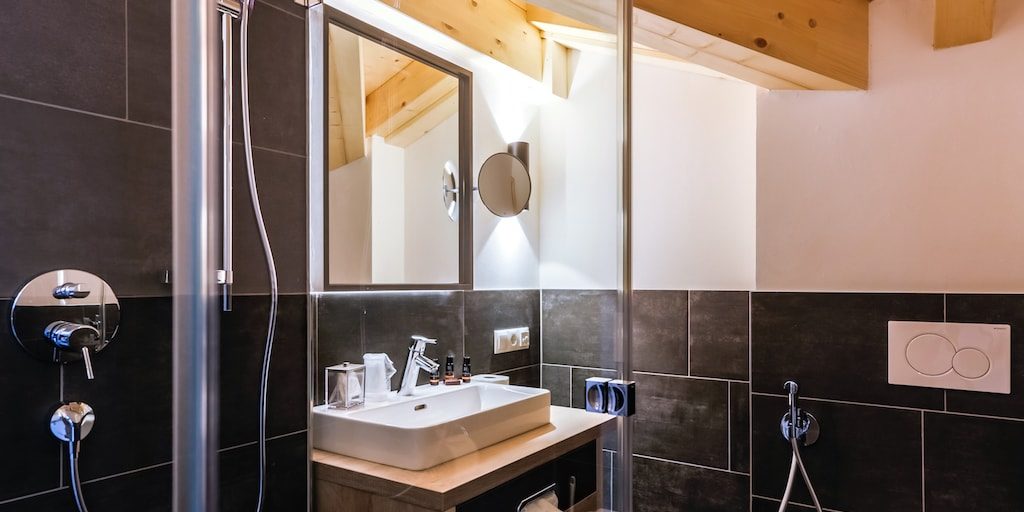 Hotel 24 by Avenida Kaprun Zell am See-Kaprun Oostenrijk wintersport skivakantie luxe Penthouse 3 slaapkamers badkamer douche wastafel spiegel houten balken