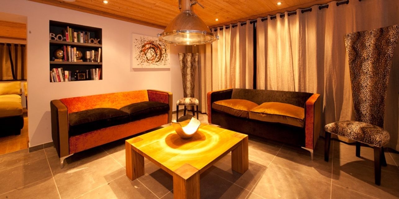 Altitude Lodge Les Gets les Portes du Soleil Frankrijk wintersport skivakantie luxe living banken salontafel fauteuils hanglamp boeken schilderij houten plafond