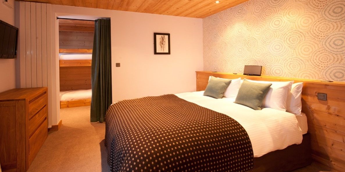 Altitude Lodge Les Gets les Portes du Soleil Frankrijk wintersport skivakantie luxe slaapkamer 2-persoonsbed cirkels behang sprei houten kast TV stapelbed houten plafond