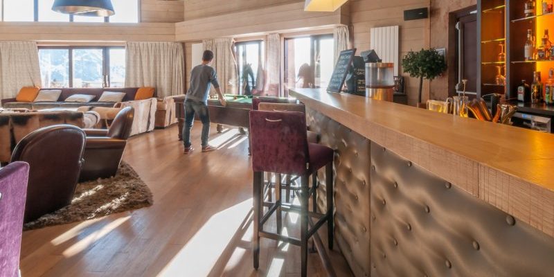 Residence l'Amara Avoriaz Les Portes du Soleil Frankrijk wintersport skivakantie luxe bar barkrukken fauteuils bank hanglamp tafelvoetbal hout vloerkleed