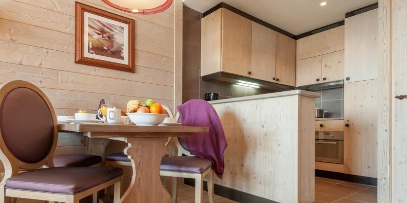 Residence l'Amara Avoriaz Les Portes du Soleil Frankrijk wintersport skivakantie luxe gedekte tafel ontbijt vers fruit stoelen keuken hout schilderij hanglamp