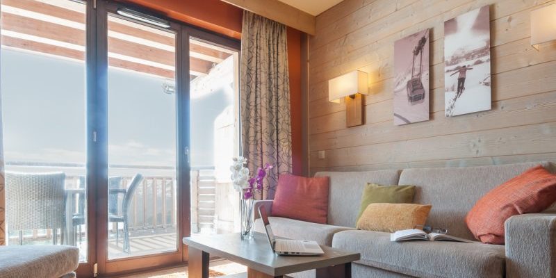 Residence l'Amara Avoriaz Les Portes du Soleil Frankrijk wintersport skivakantie luxe living bank gekleurde kussens salontafel laptop schilderijen wandlampen balkon tafel stoelen bergen sneeuw