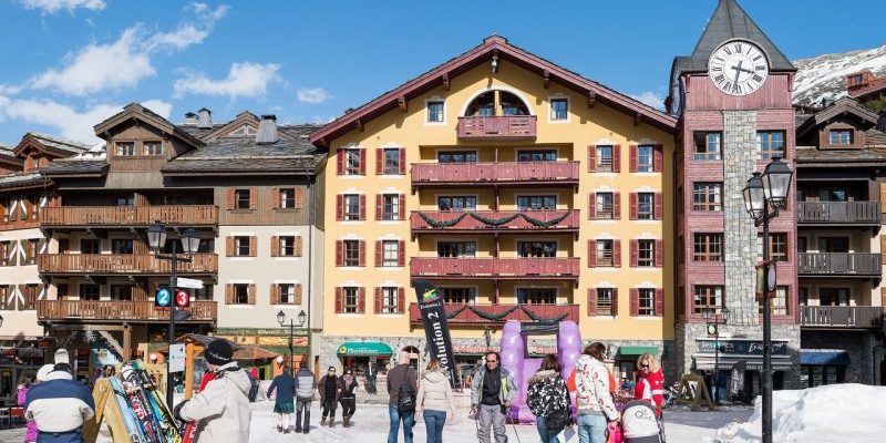 Arc 1950 Paradiski Frankrijk wintersport skivakantie luxe dorp klok lantarenpaal dorpsplein mensen bergen sneeuw